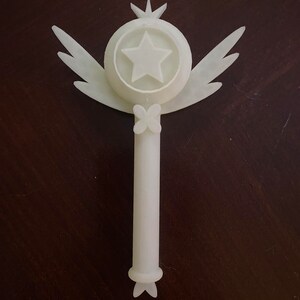 May include: White plastic wand with a star and wings at the top and a butterfly design at the bottom.