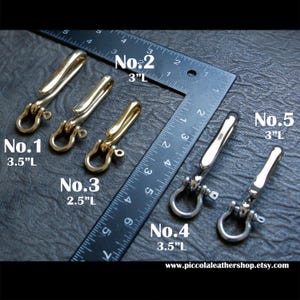 May include: A collection of metal swivel clasps in gold and silver tones, displayed with a ruler for size comparison. The clasps are labeled with numbers and lengths: No. 1 (3.5"L), No. 2 (3"L), No. 3 (2.5"L), No. 4 (3.5"L), and No. 5 (3"L).