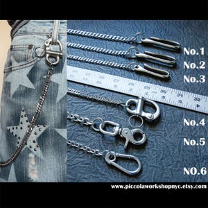 May include: Close-up of six silver-toned metal chain wallet accessories. The chains have various clasp styles, including lobster claw and carabiner clips. The image also shows a pair of blue jeans with star-shaped embellishments. The website address is visible at the bottom.