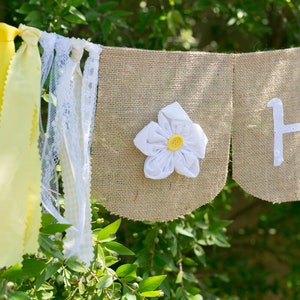 Happy Birthday Banner With White Flowers and Yellow Ribbons Makes