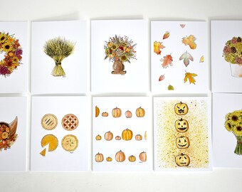 Könnte beinhalten: Eine Sammlung von zehn Aquarell-Grußkarten mit herbstlichen Illustrationen. Designs umfassen einen Sonnenblumenkranz, Weizen, Blumenarrangements, fallende Blätter, Kürbisse, Kuchen und Kürbislaternen. Die Karten befinden sich auf einem weißen Hintergrund.