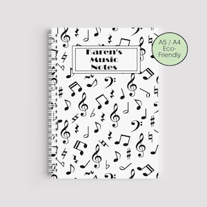 Puede incluir: Un cuaderno de espiral blanco con un patrón de notas musicales y símbolos negros. El texto "Karen's Music Notes" se muestra en un marco rectangular. Una pegatina "A5 / A4 Eco-Friendly" está en la esquina superior derecha.