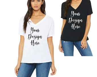 Op de afbeelding: Twee vrouwen dragen V-hals T-shirts met de tekst "Your Design Here" op de voorkant. De shirts zijn verkrijgbaar in wit en zwart.
