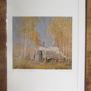 May include: A painting depicting a small cabin nestled amongst birch trees with yellow leaves. The artwork is titled "The Guide's Home, Algonquin" and signed "Arthur Lismer".