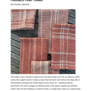 May include: Four woven kitchen towels in a waffle weave pattern with a pink and white color scheme. The towels are folded and stacked on a wooden surface. The text "Fibonacci Float Towels" is visible at the top of the image.