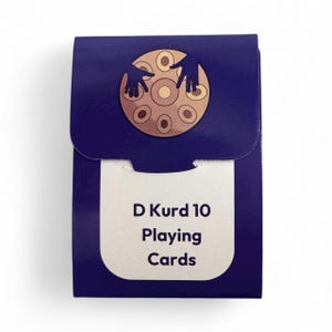 May include: A navy blue playing card box with a white label. The label reads "D Kurd 10 Playing Cards." The box features a brown and tan circular design with two hands above it.