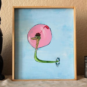 May include: A painting of a green snake with a brown hat inside a pink bubble on a light blue background.
