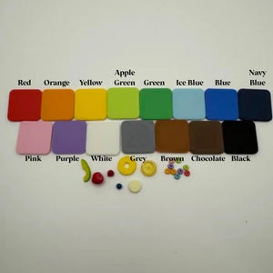 May include: A collection of colorful square tiles in various shades, including red, orange, yellow, green, blue, and black. Additional small decorative elements like fruit and beads are also present. The colors are labeled with text.
