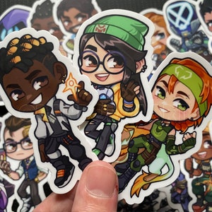 Puede incluir: Un conjunto de nueve pegatinas de personajes de dibujos animados coloridos. Las pegatinas presentan personajes con diferentes tonos de piel, colores de cabello y ropa. Los personajes son todos sonrientes y parecen estar de buen humor.