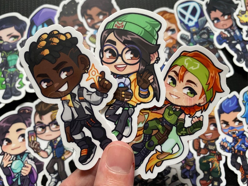 Puede incluir: Un conjunto de nueve pegatinas de personajes de dibujos animados coloridos. Las pegatinas presentan personajes con diferentes tonos de piel, colores de cabello y ropa. Los personajes son todos sonrientes y parecen estar de buen humor.