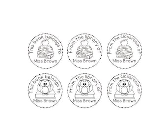 May include: Six circular book stamps with black text and illustrations. Three stamps feature a stack of books topped with an apple, and the text "This book belongs to", "From the library of", and "From the classroom of". The other three stamps feature an owl.