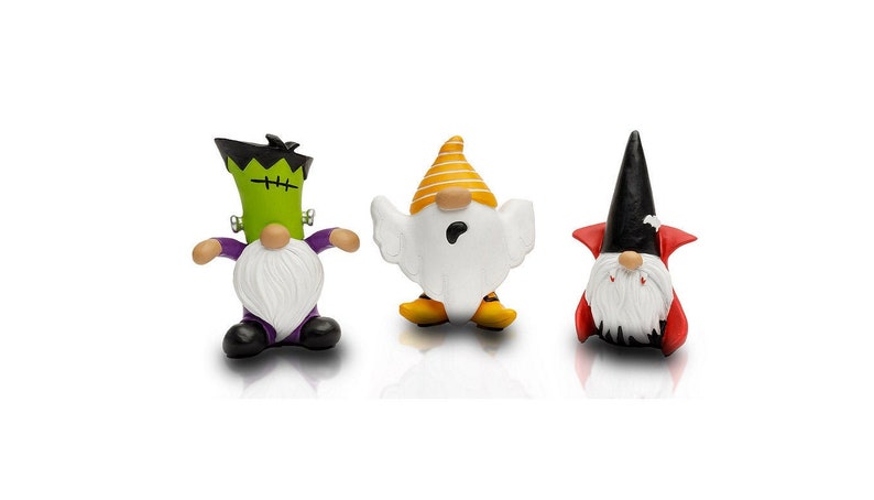 K&ouml;nnte beinhalten: Drei Halloween-Zwergfiguren. Einer ist ein Frankenstein-Monster mit gr&uuml;ner Haut und schwarzen Haaren. Ein weiterer ist ein Geist mit einem gelb-wei&szlig; gestreiften Hut. Der letzte ist ein Vampir mit schwarzem Umhang und Hut.