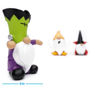 K&ouml;nnte beinhalten: Ein Set von Halloween-Gnom-Figuren. Die Hauptfigur ist ein Frankenstein-Monster-Gnom, etwa 10 cm hoch und 5 cm breit, mit gr&uuml;nem Kopf, schwarzem Haar und wei&szlig;em Bart. Zwei weitere Gnomfiguren befinden sich im Hintergrund.