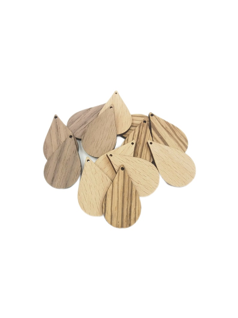 May include: A group of wooden teardrop-shaped pendants with a hole at the top. The pendants are made of light and dark wood with a natural grain pattern.