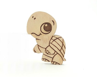 May include: A wooden cutout of a cartoon turtle with large eyes. The turtle is brown and has a detailed shell.