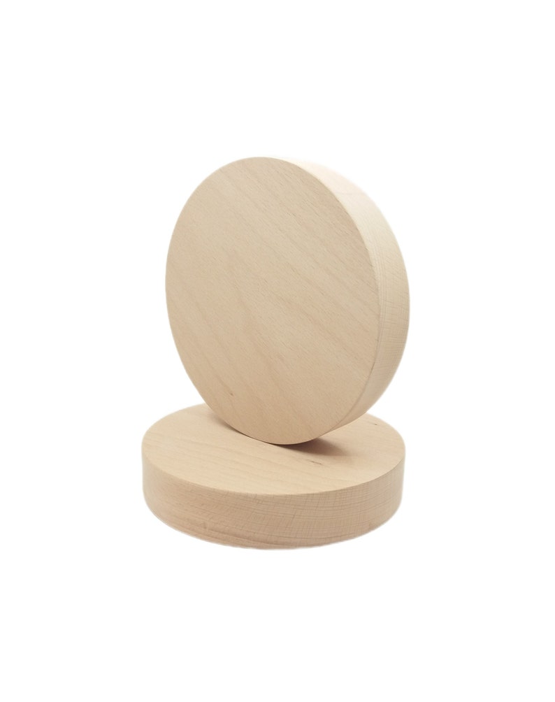 May include: Two unfinished wooden circles stacked on top of each other. The top circle is slightly larger than the bottom circle.