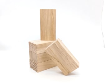 Puede incluir: Una pila de cuatro bloques de madera, con un bloque de pie en la parte superior de la pila.
