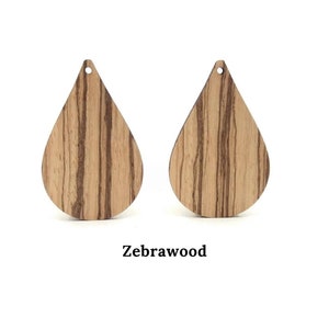 May include: Two teardrop-shaped wooden earrings made from zebrawood. The earrings have a hole at the top for hanging.