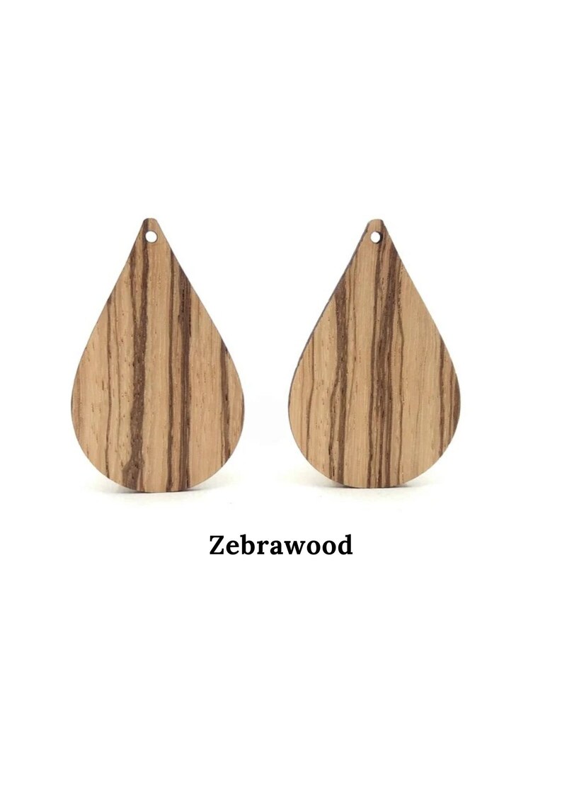 May include: Two teardrop-shaped wooden earrings made from zebrawood. The earrings have a hole at the top for hanging.