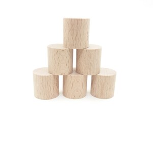 Peut inclure: Un ensemble de six cylindres en bois empil&eacute;s en forme de pyramide. Les cylindres sont tous de la m&ecirc;me taille et sont en bois brun clair.