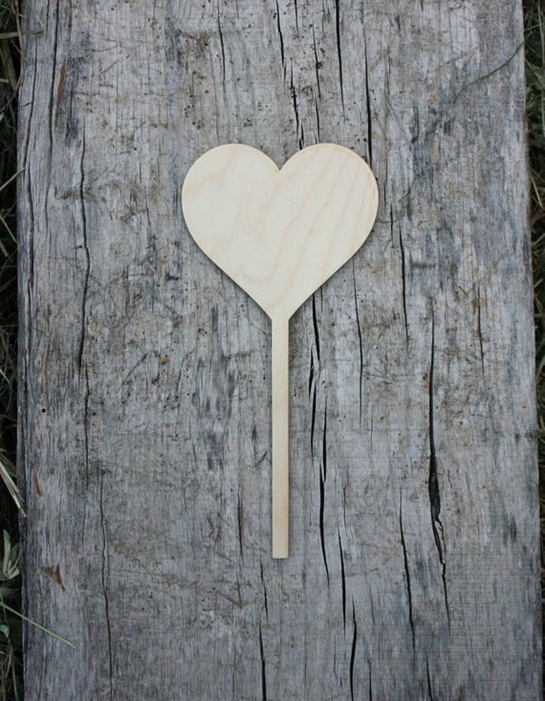 May include: A wooden heart-shaped sign on a stick. The sign is blank and ready to be decorated.