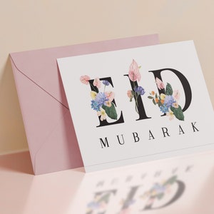 May include: A white card with the words "Eid Mubarak" in black lettering. The "Eid" is decorated with colorful flowers.