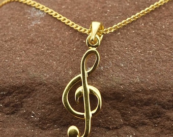 May include: A gold treble clef pendant necklace. The pendant is a simple, elegant design and hangs from a delicate gold chain.