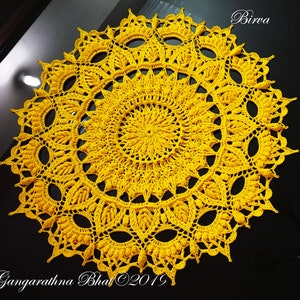 May include: A large, yellow crochet doily with a circular design. The doily has a center with a smaller circular design and multiple layers of intricate crochet work.