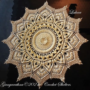 Puede incluir: Un gran encaje de ganchillo intrincado en color crema con un diseño de estrella. El encaje está hecho con puntadas delicadas y tiene un círculo central con un patrón en espiral. El texto "Lahari" está escrito en la esquina superior derecha de la imagen. El texto "Gangarathna ©2021 Crochet Shelters" está escrito en la esquina inferior izquierda de la imagen.