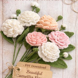 May include: A bouquet of handmade crochet camellia flowers in shades of white, peach, and pink, with green leaves and stems. The words "CROCHET PATTERN" are at the top, and a tag reads "Beautiful Camellia Flowers".