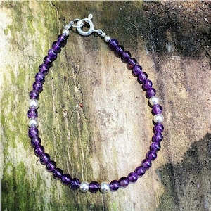 May include: A purple amethyst and silver bead bracelet with a silver clasp.