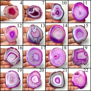 May include: A collection of sixteen polished agate slices in various shades of pink and purple, each featuring unique concentric banding patterns and crystalline centers, displayed in a grid format with numerical labels from 4 to 22.