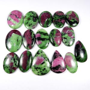 Peut inclure: Une collection de 15 cabochons de pierres précieuses vertes, roses et noires. Les cabochons sont de forme ovale et en forme de poire.