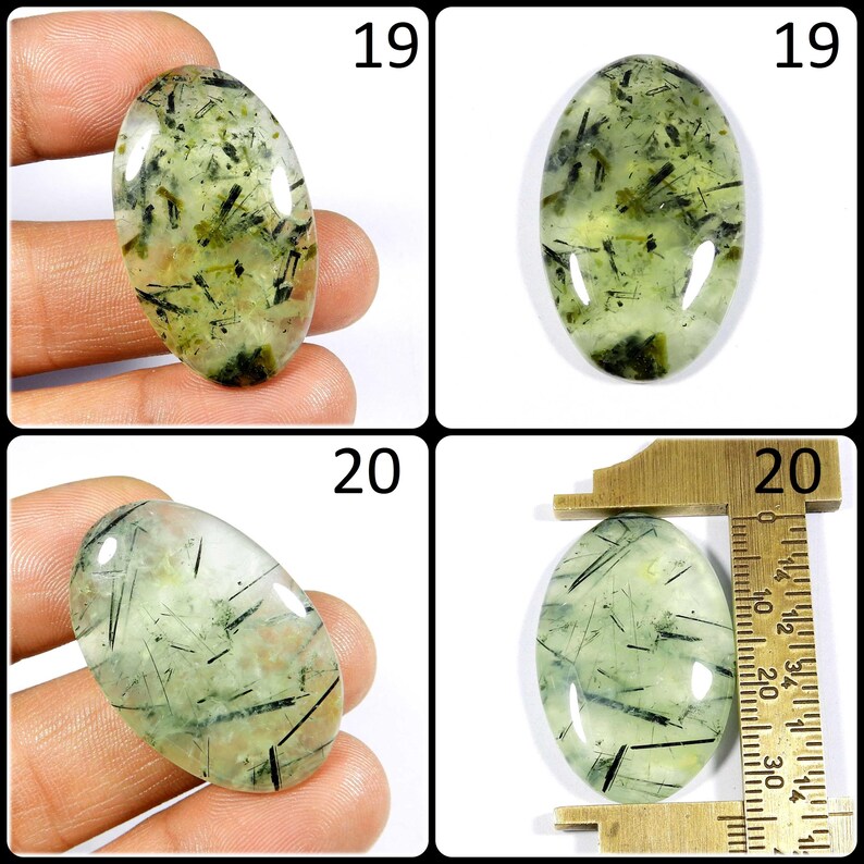 May include: Two oval-shaped green and black gemstone cabochons, one is being measured with a ruler, the other is being held in a hand. The ruler shows measurements in inches. The cabochons are approximately 1 inch in length.