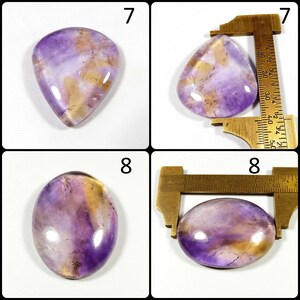 May include: Four polished gemstones with a mix of purple and gold hues. Two are teardrop-shaped, and two are oval. Measurements are shown in centimeters. The gemstones are displayed against a white background.
