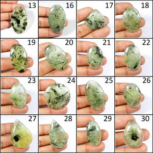 May include: Assortment of 18 green and black cabochon gemstones, each with a unique pattern and shape. The stones are displayed on a hand, with numbers 13 through 30 printed above each stone.