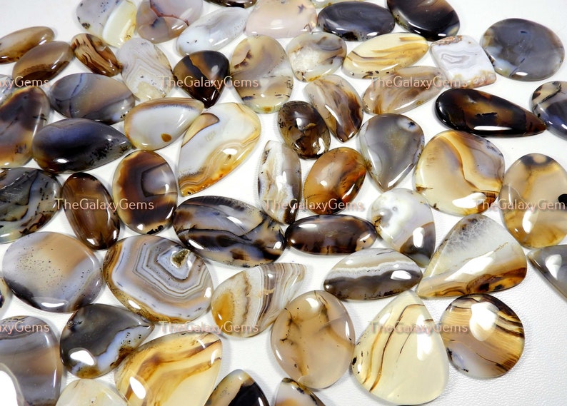 May include: A collection of agate cabochons in various shades of brown, white, and gray. The cabochons are smooth and polished, with intricate patterns of banding and inclusions. The cabochons are ideal for jewelry making, crafting, and other creative projects.