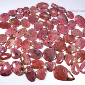 May include: A collection of 30 pink and white gemstone cabochons, with a variety of shapes and sizes. The stones are smooth and polished, with a natural, organic look.