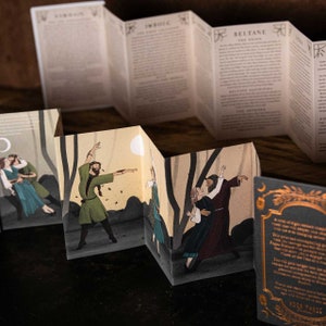 May include: A folded paper booklet with illustrations of people dancing in a forest. The booklet has text about the Celtic festival of Beltane. The text includes the words "Beltane, The Fire God, The Origins".
