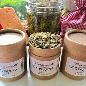 May include: Three brown cardboard tubes with white labels containing dried oregano. The labels read "White Dormouse Artisan Goods 100% Natural Oregano" and "Net Wt. 0.40 oz/11g".