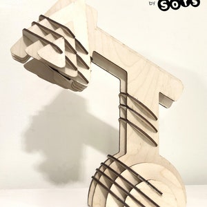 May include: A wooden desk lamp made of interlocking pieces. The lamp is assembled and has a natural wood finish. The text "DESK LAMP by Sofs" is visible in the image. The text "LAMPE DE TABLE Modèle 3D enclenché" is also visible in the image.