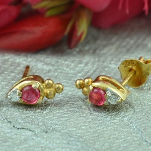 Peut inclure: Une paire de boucles d'oreilles en or avec une pierre précieuse rose et un petit accent diamant. Les boucles d'oreilles portent le poinçon 925 au dos.