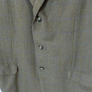 May include: A brown blazer with a subtle blue and yellow plaid pattern. The blazer has four buttons down the front.