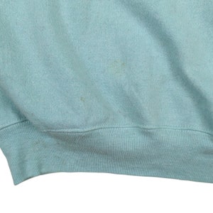 Puede incluir: Una sudadera azul claro con un dobladillo de canal&eacute;.