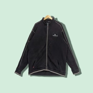 May include: A black zip-up jacket with white piping and a Quiksilver logo on the chest.