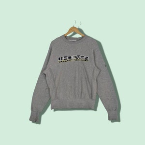 May include: Grey sweatshirt with a navy blue and white logo that reads "WHOEVER PURPOSE PRODUCE".