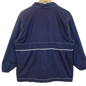 May include: A navy blue windbreaker jacket with white stitching and a zipper closure.