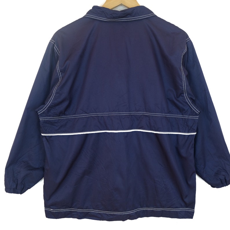 May include: A navy blue windbreaker jacket with white stitching and a zipper closure.