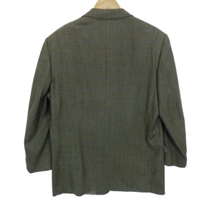 May include: A brown tweed blazer with a single button closure. The blazer has a classic fit and a slightly textured fabric.