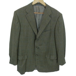 May include: A brown tweed blazer with a three-button closure and flap pockets.